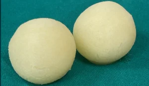 Two white round sweets on fabric.