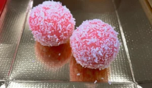 Two pink coconut-covered dessert balls.
