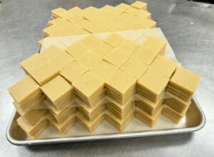 Stacked squares of light-colored fudge.