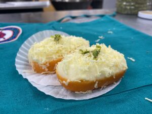 Cheese-topped pastries on a blue cloth.