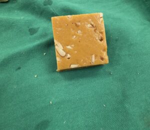 Square piece of nutty fudge on fabric.
